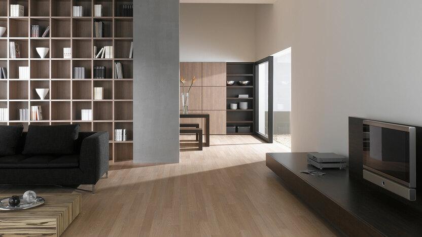 Offene Wohnraumimpression mit Einbauregal in Trennwand Offene Wohnraumimpression mit Einbauregal für Bücher und Dekoration in Trennwand mit hellem Holzboden